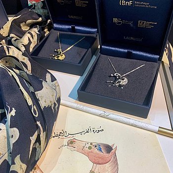 FBM 2023, Frankfurter Buchmesse 2023. Merchandising Produkte, Pegasus, Goldkette und Silberkette sowie Seidenschal aus der Reihe von Medieval Art Stories ★ Universal Art Group