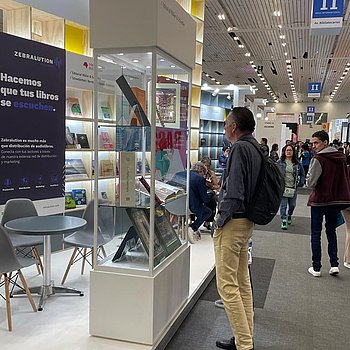 FIL 2023: Glasvitrine des Faksimile Verlags und des Verlags Müller und Schindler am Deutschen Gemeinschaftsstand auf der Buchmesse in Guadalajara, Mexiko. Die Faksimile und edlen Einzelseiten werden von Besuchern bewundert. ★ Universal Art Group